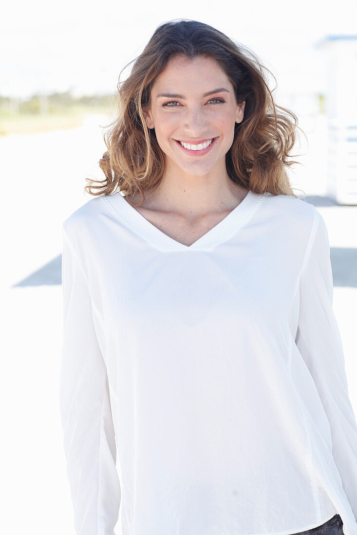 A young woman wearing a white long-sleeved blouse