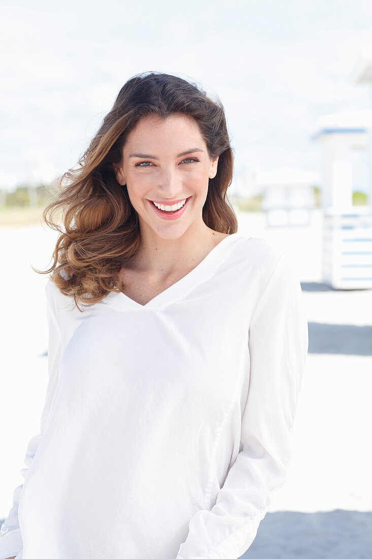 A young woman wearing a white long-sleeved blouse