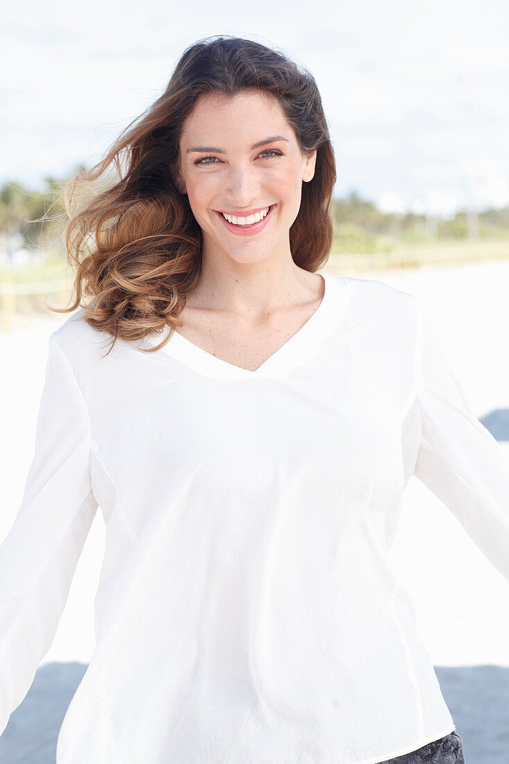 A young woman wearing a white long-sleeved blouse