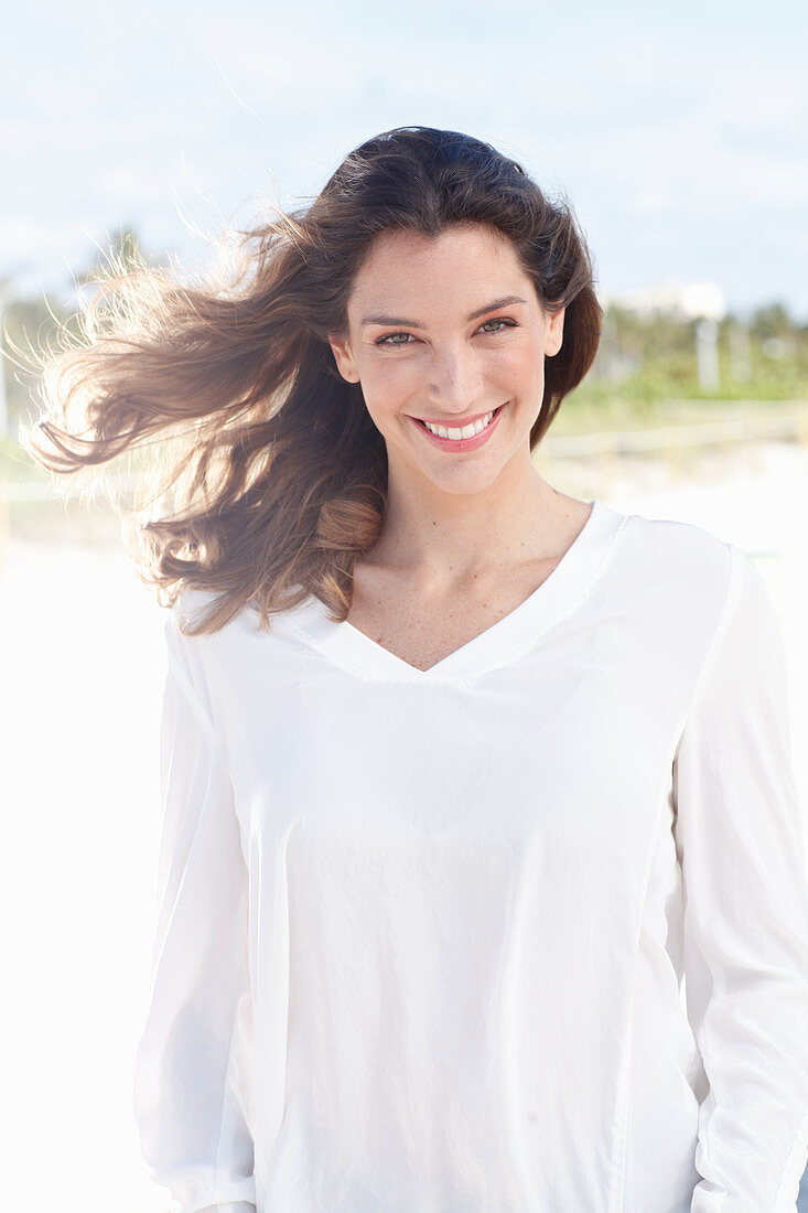 A young woman wearing a white long-sleeved blouse