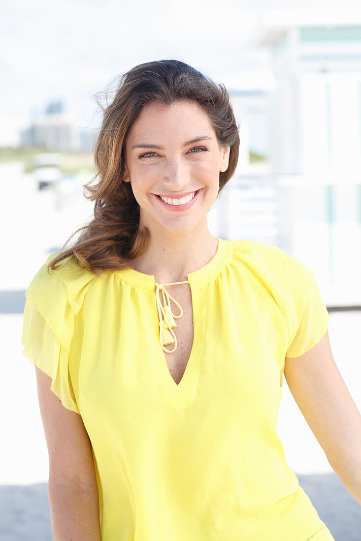 A young woman wearing a yellow sleeveless top