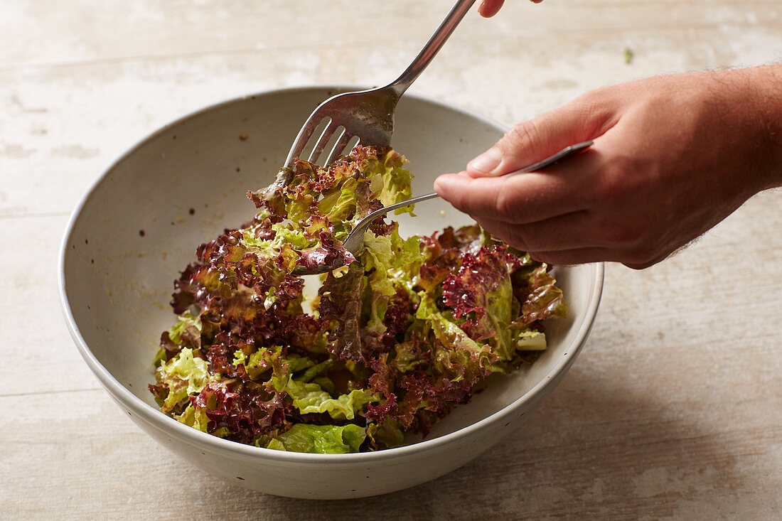 Lettuce being mixed before serving