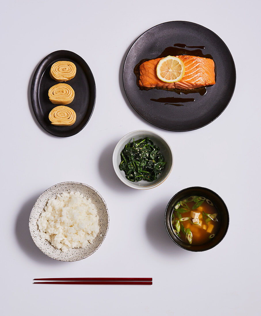 A Japanese meal with dashi broth, salmon, omelette, spinach and rice