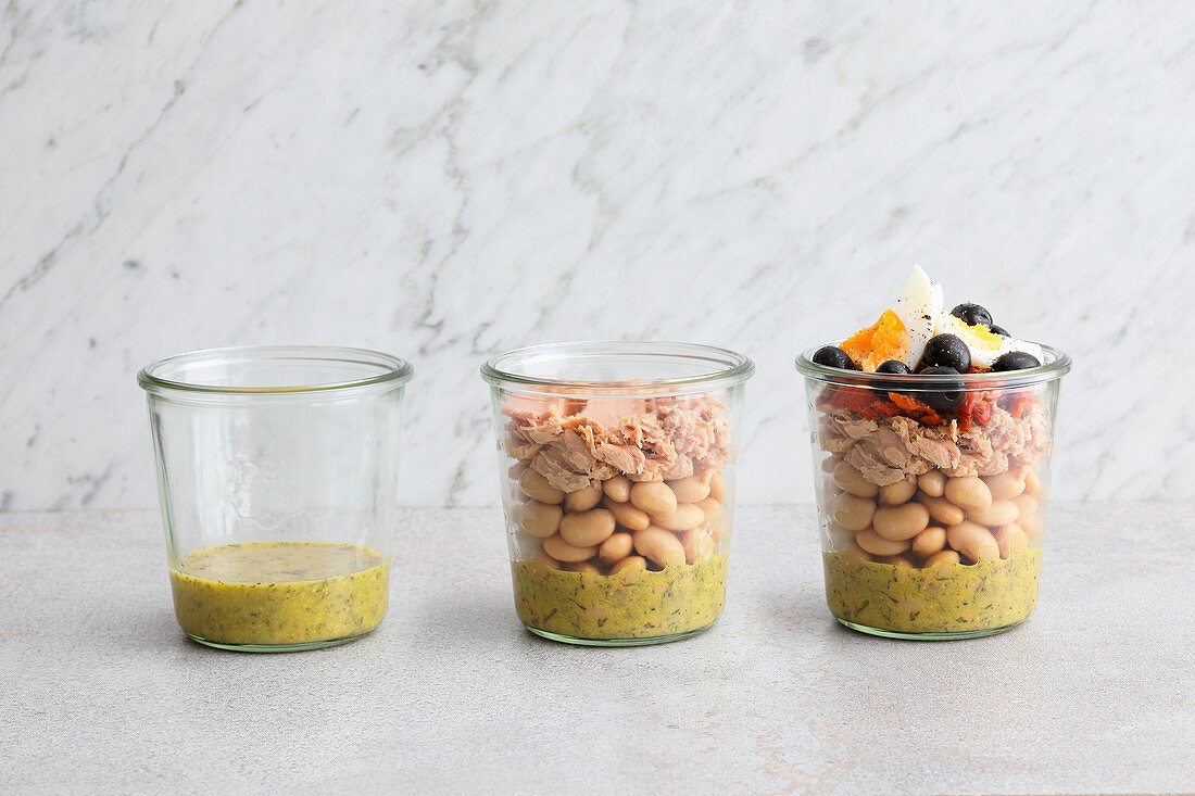 A salad being layered in a jar