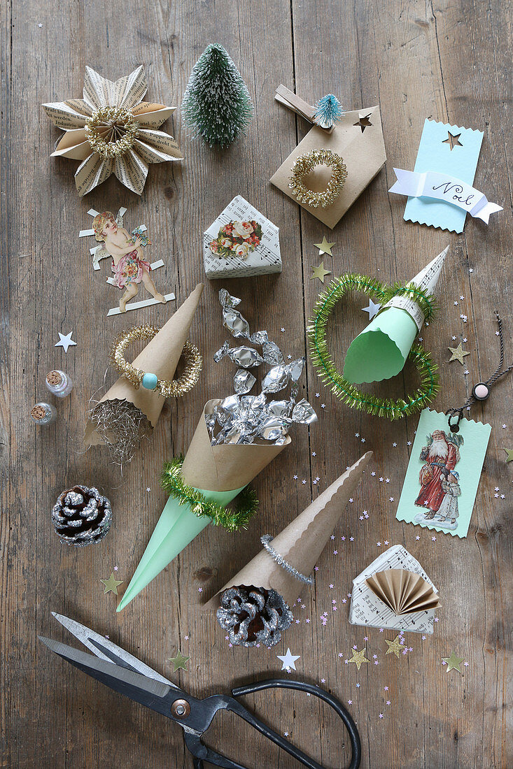 Handcrafted, paper Christmas decorations, cones of sweets, pictures of roses, scissors and glitter
