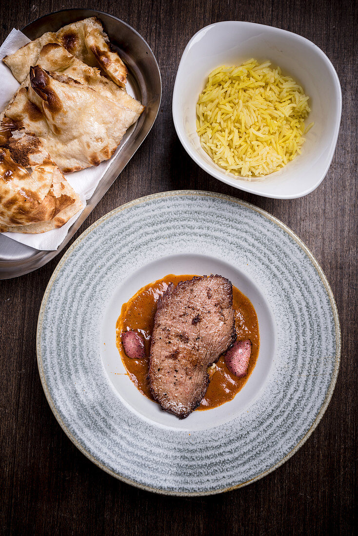 Ostrich steak served with rice and flatbread (India)