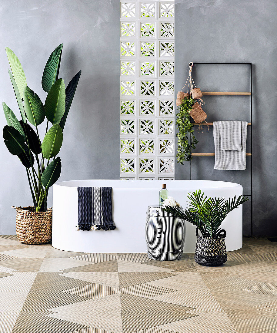 Freestanding bathtub, towel dryer and indoor plants in the bathroom