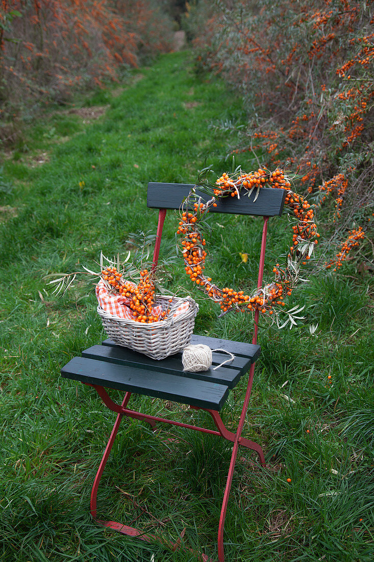 Homemade sea-buckthorn wreath and sea-buckthorn branches in a basket