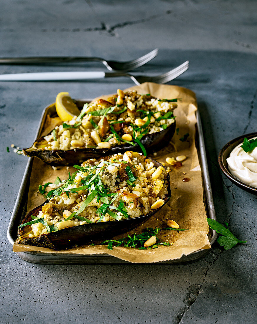 Baked eggplant halves with couscous filling and a tahini dip