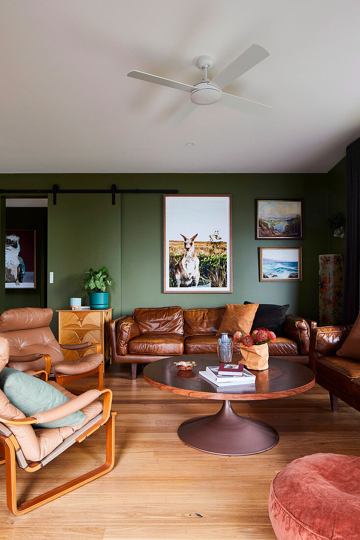 Living room in brown and green with leather sofas and leather armchairs