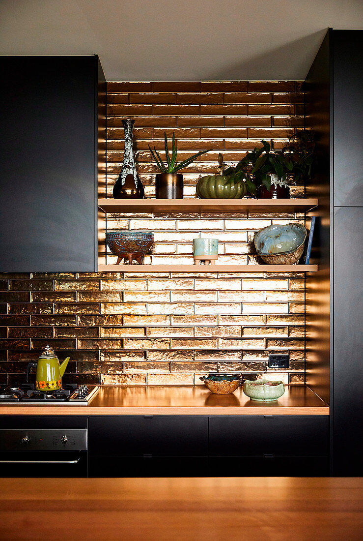 Golden tiles in the kitchen with black fronts