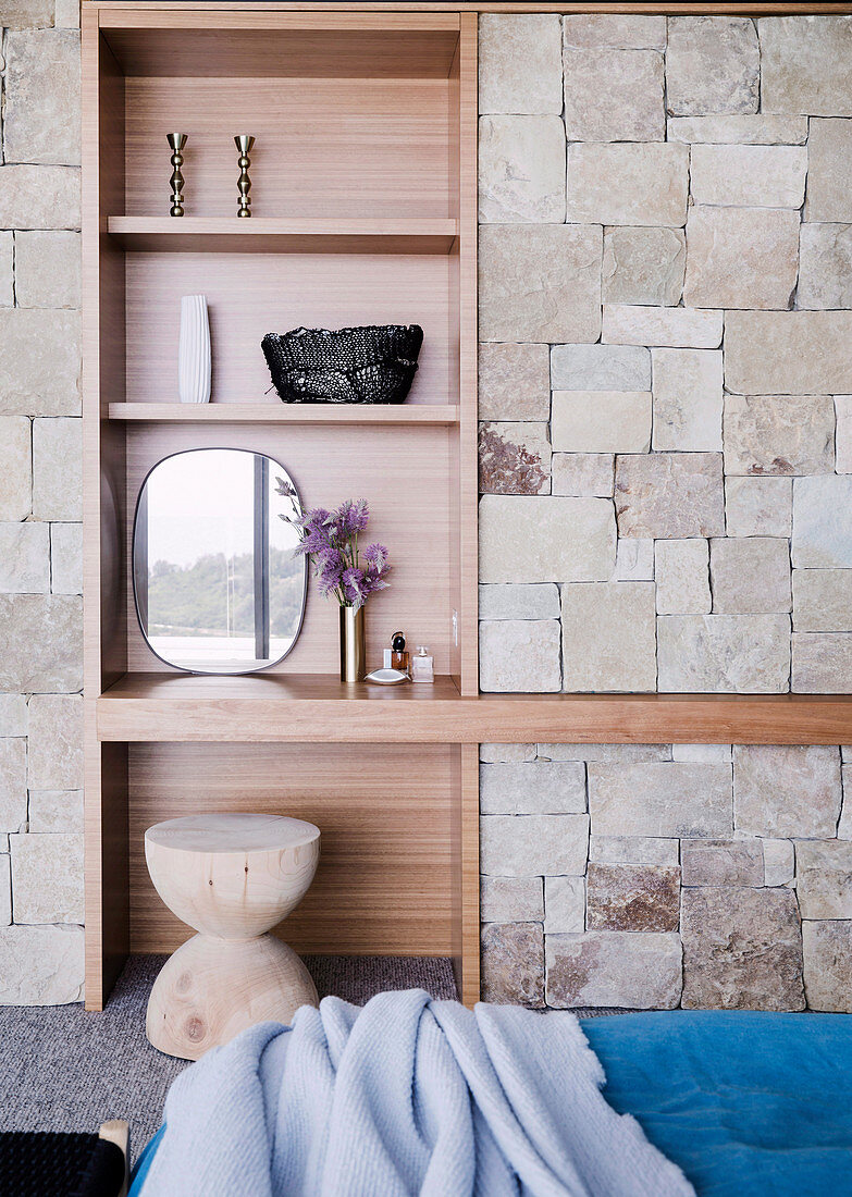 Built-in shelf in a natural stone wall in the bedroom