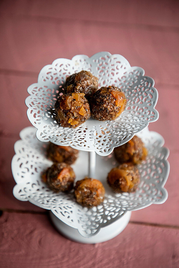 Chia apricot balls with lime and coconut on a cake stand