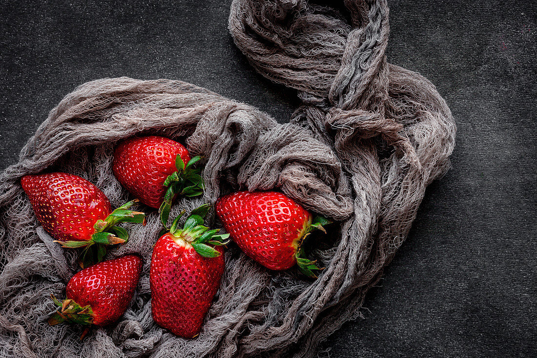 Red and fresh strawberries flat lay in a piece of cloth