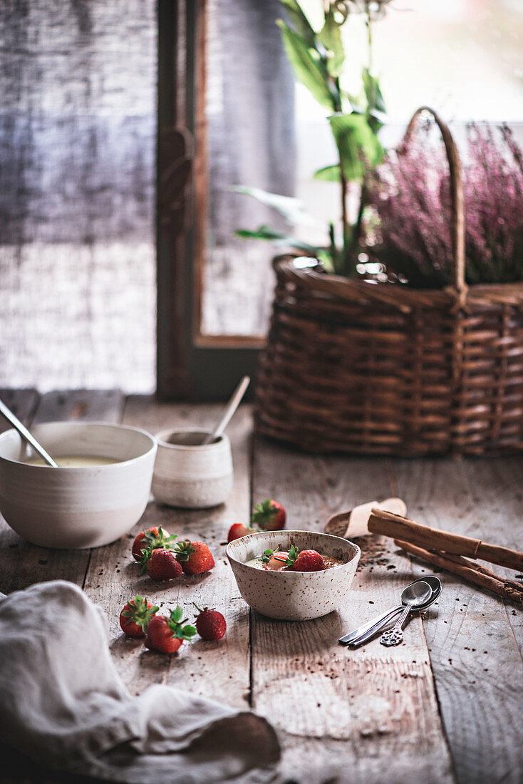 Porridge mit Gewürzen und Erdbeeren auf Holztisch