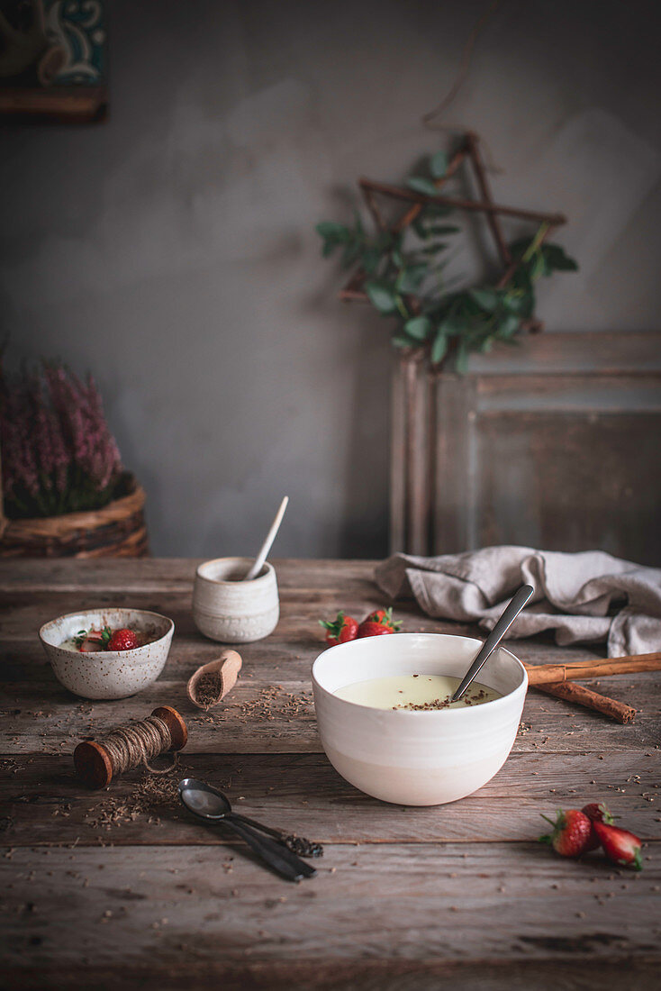Porridge mit Gewürzen und Erdbeeren auf Holztisch
