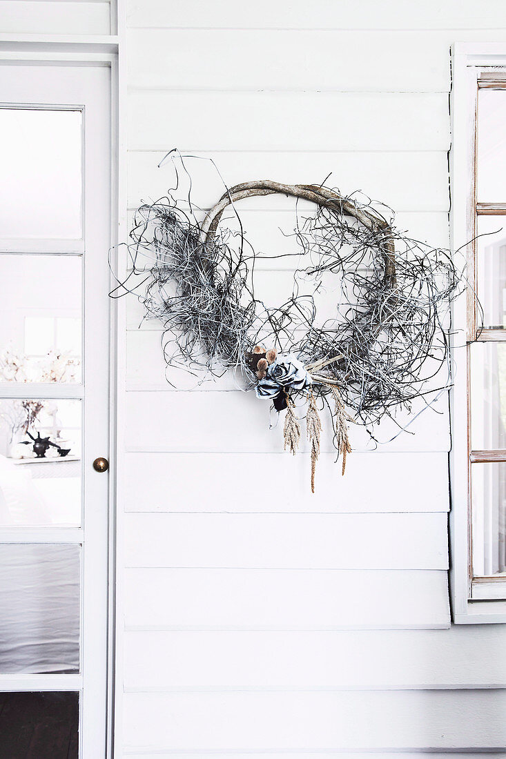 Wreath of found objects from nature on the house wall