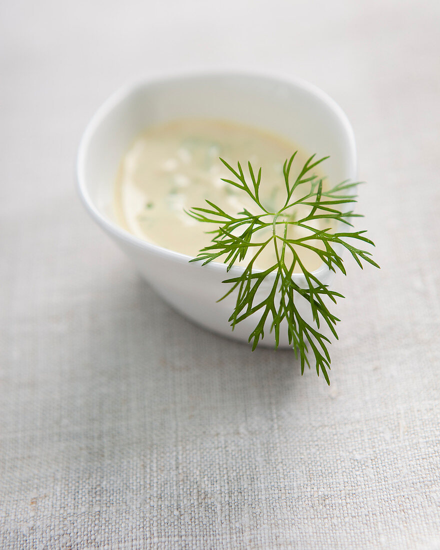 A mustard dip with dill in a small bowl