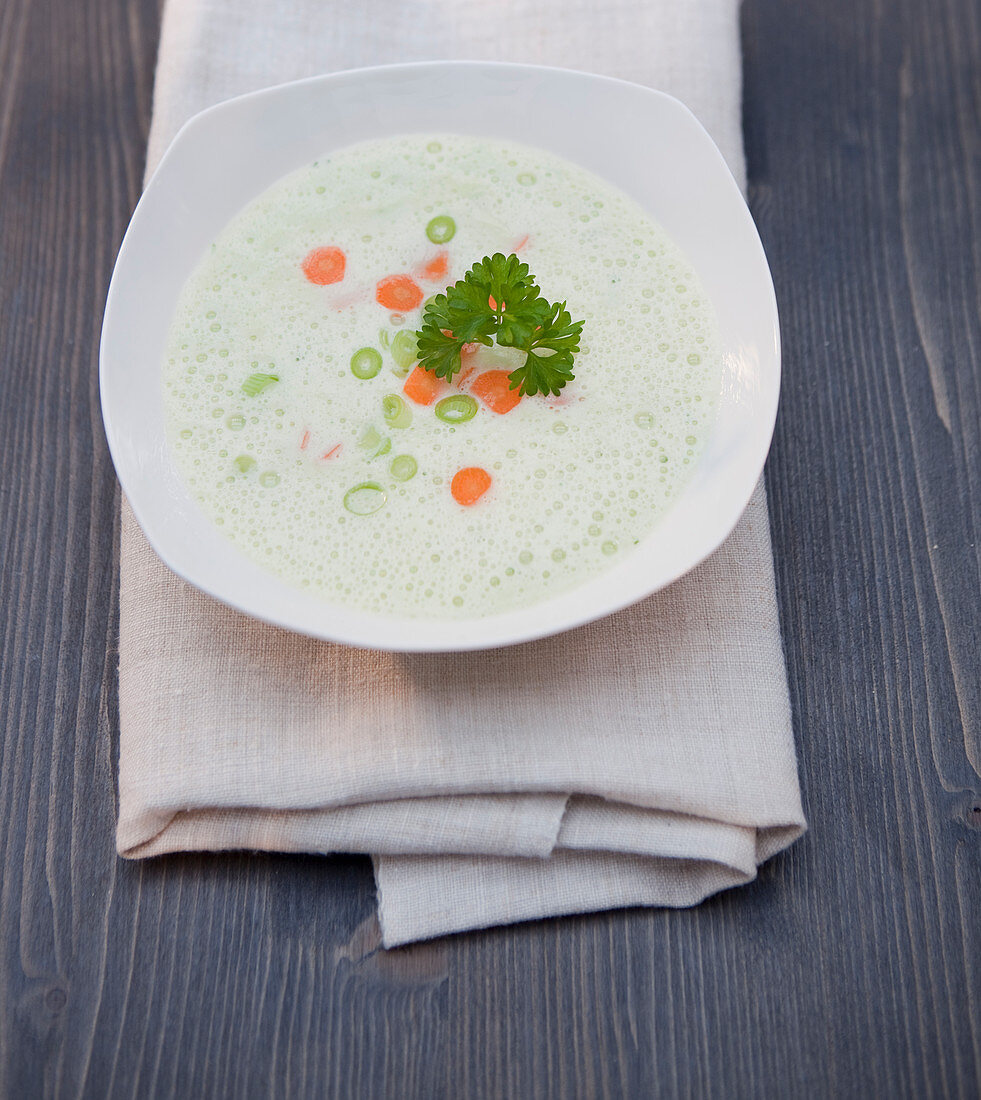 Cream foam soup with spring onions, carrots and parsley