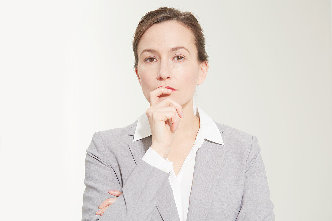 A business woman holding her index finger to her lips