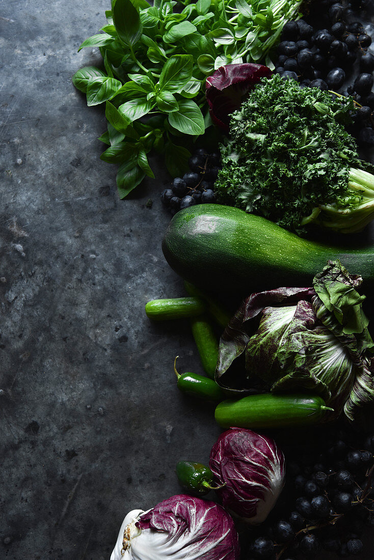 Stilleben mit grünem Gemüse, Trauben, Radicchio und Basilikum