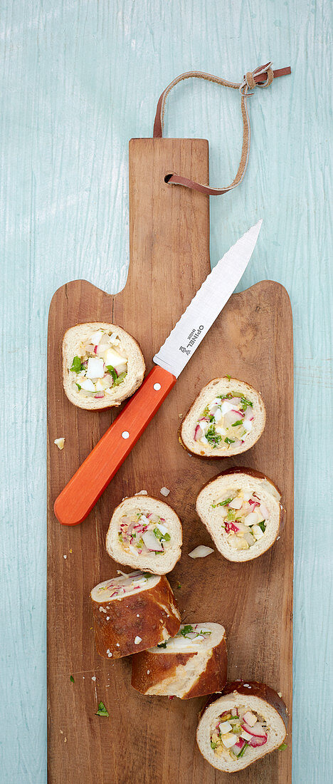 A lye bread roll filled with radishes, egg and quark