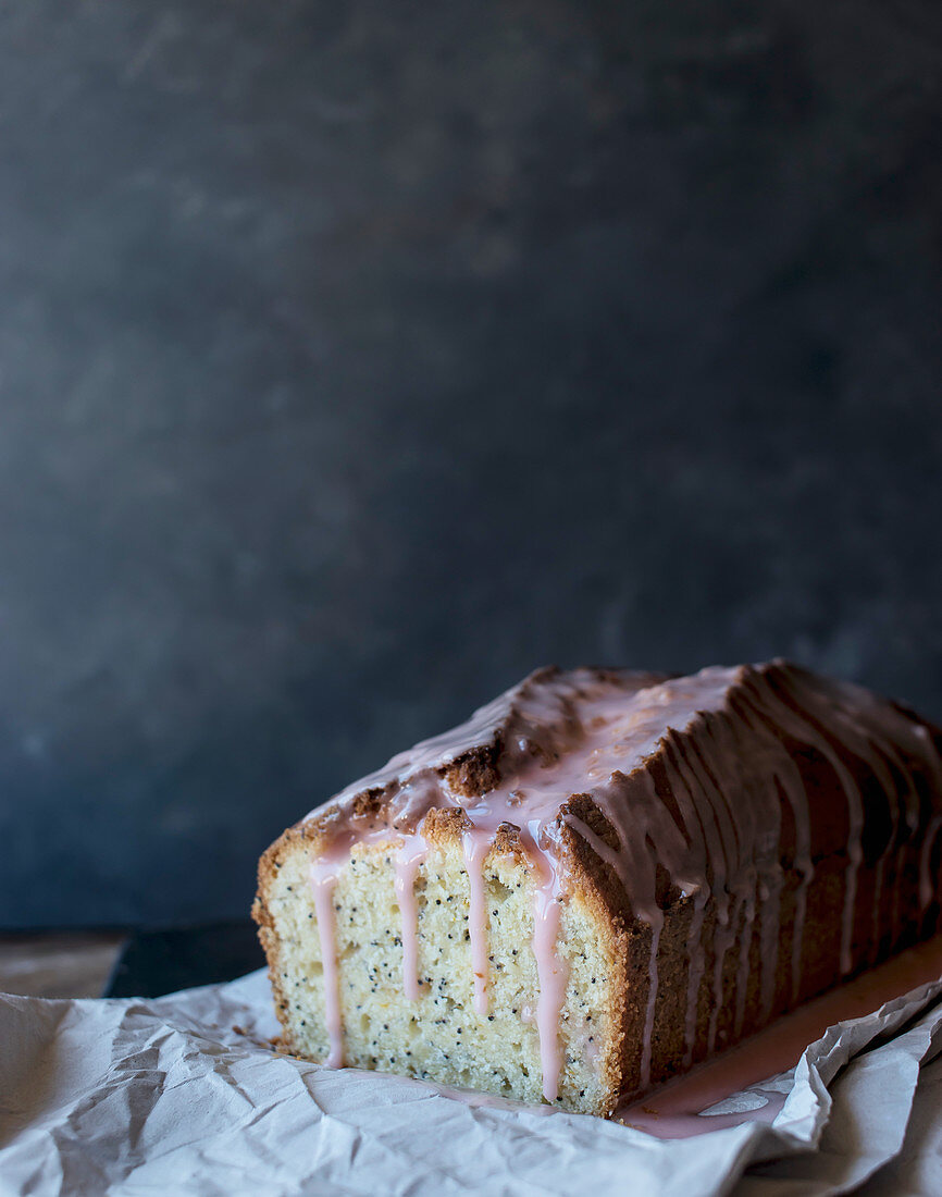 Fresh tasty orange cake with poppy seeds and topping on craft paper