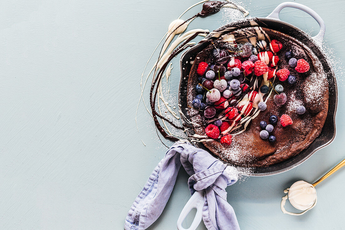 Chocolate pancake with frozen berries and white chocolate sauce