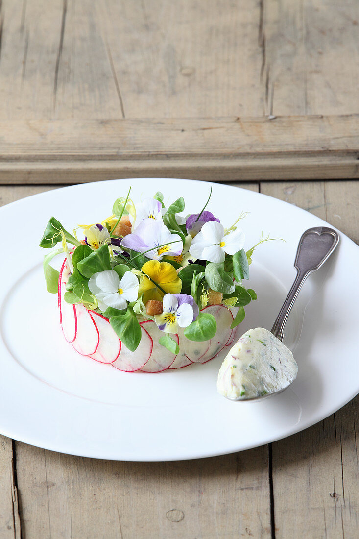 Potato salad spread with sour cream and edible flowers