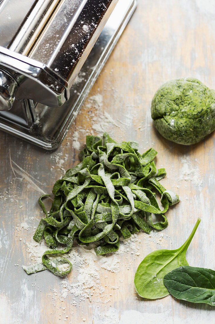 Spinach pasta dough homemade cut into tagliatelle with dough and pasta maker