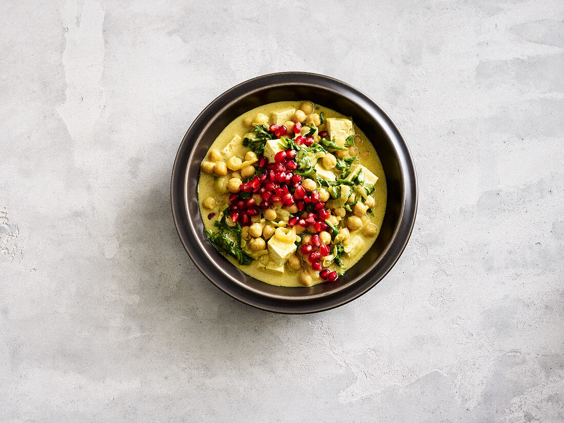 Chickpea curry with tofu, spinach and pomegranate seeds