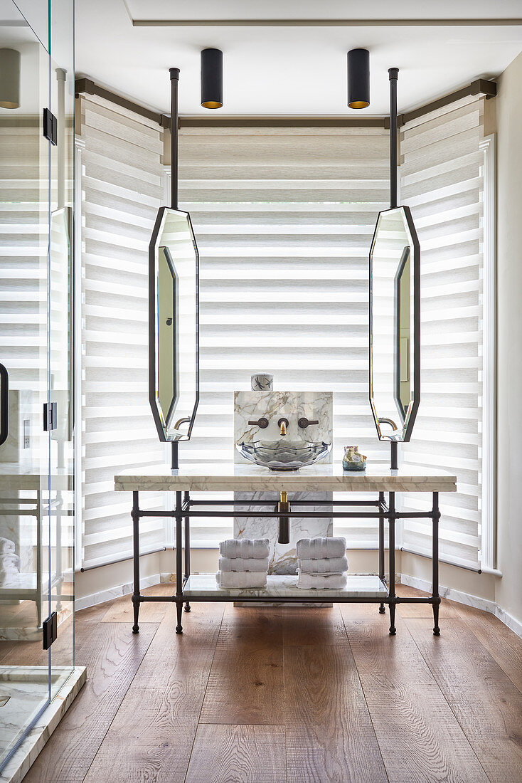 Vintage mirrors above marble washstand with glass basin