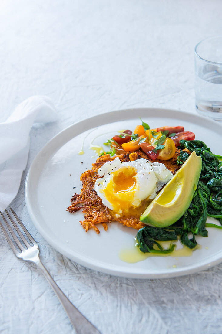 Sweet potato cake with poached egg, spinach, avocado and tomatoes