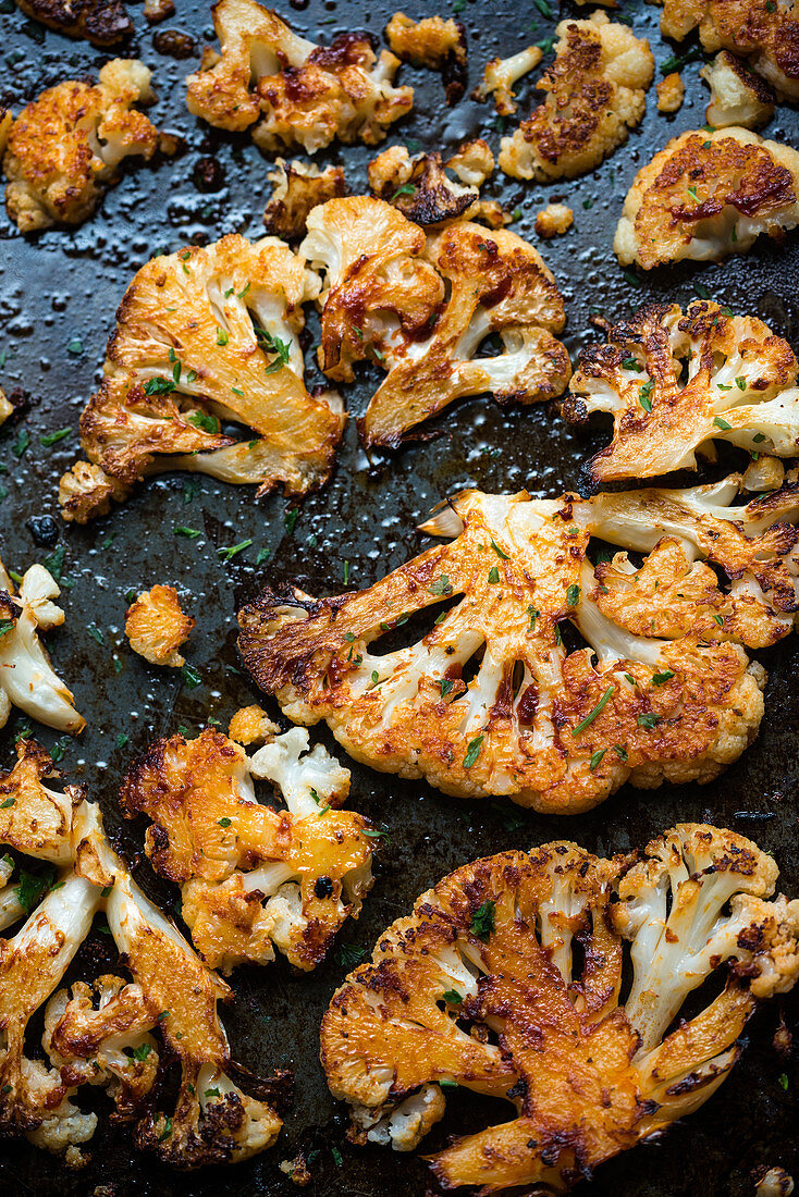 Spicy marinated, oven-baked cauliflower on a baking tray