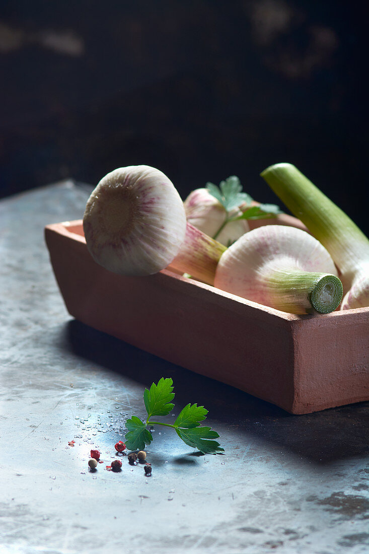 Frischer Knoblauch in Schale mit Petersilie