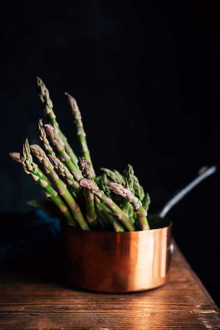 Green asparagus in a copper pot
