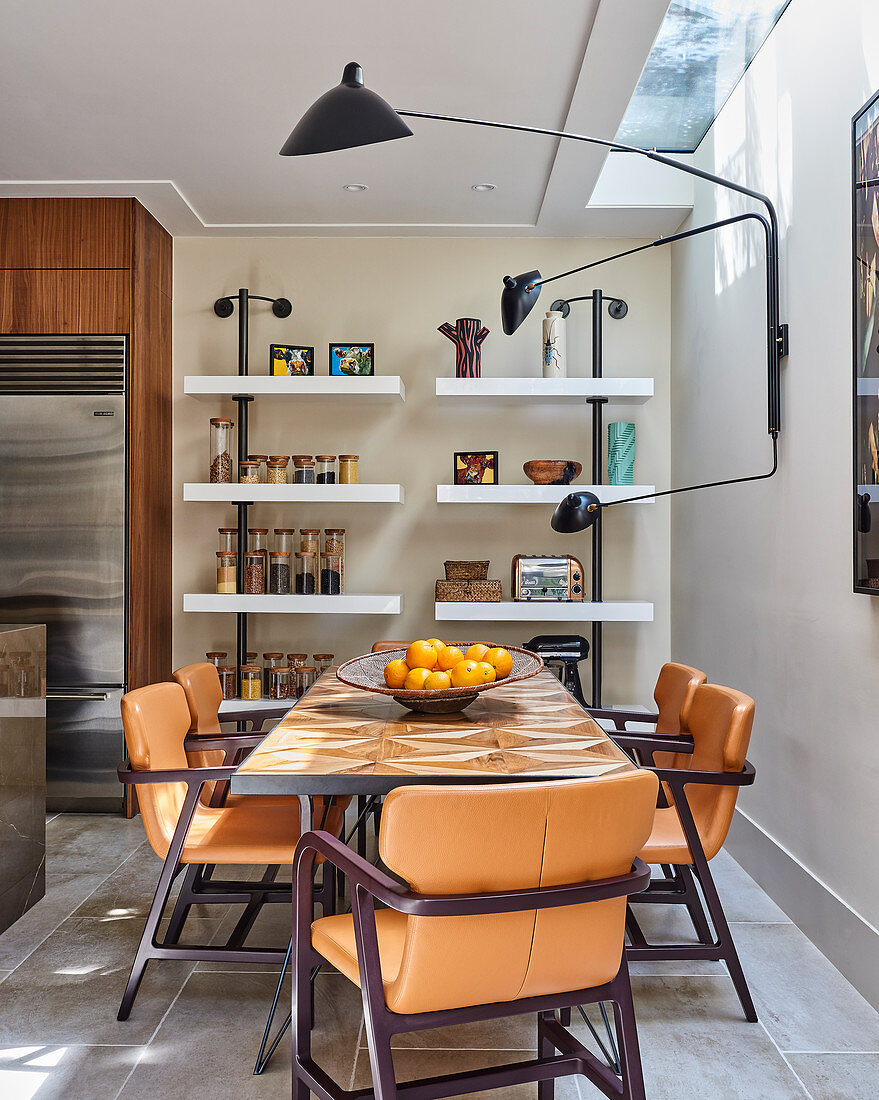 Designer lamp above table and leather chairs in dining area