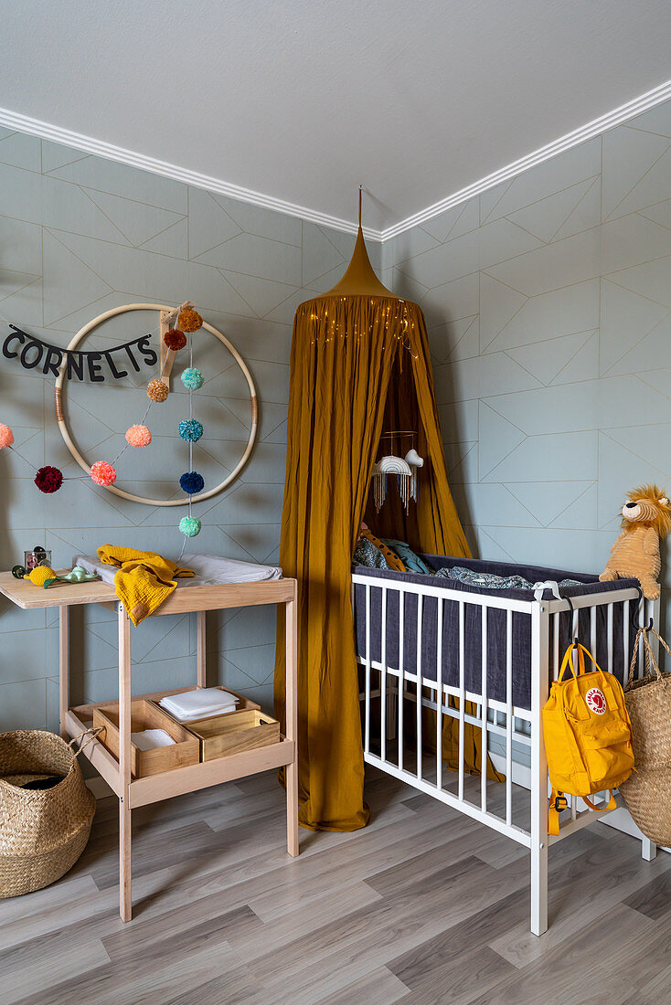 Changing table and cot in room with pale grey walls