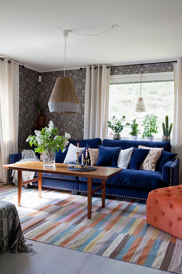 Dark blue sofa and vintage-style wallpaper in living room