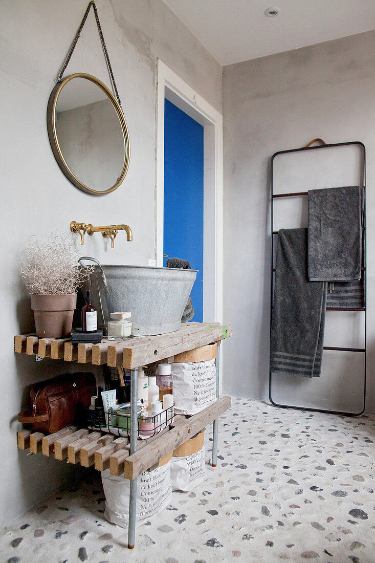 Sink made from rustic zinc tub on open wooden shelves in bathroom