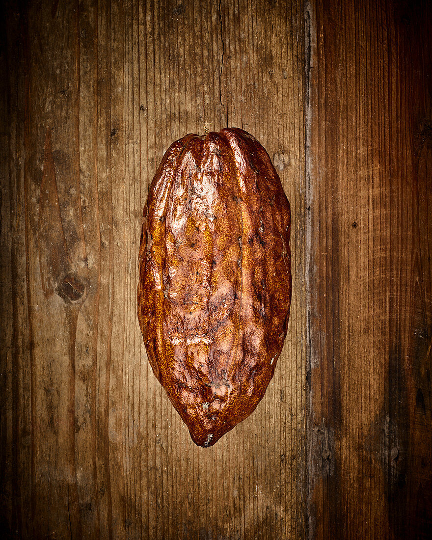 A cocoa pod on a wooden background