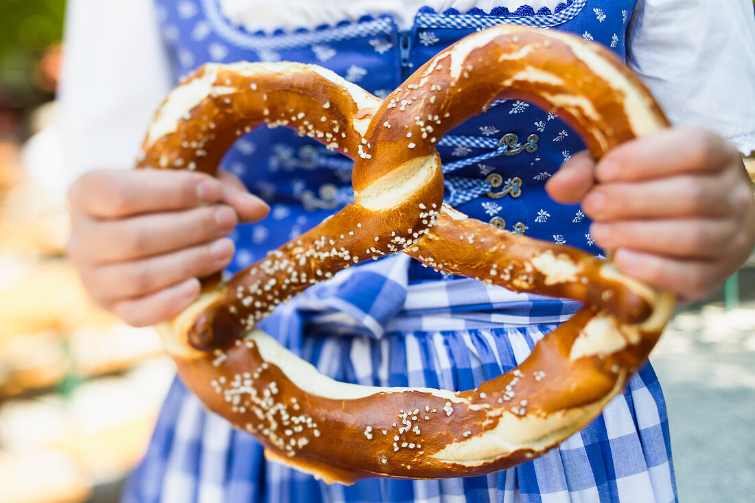 A woman holding a big pretzel