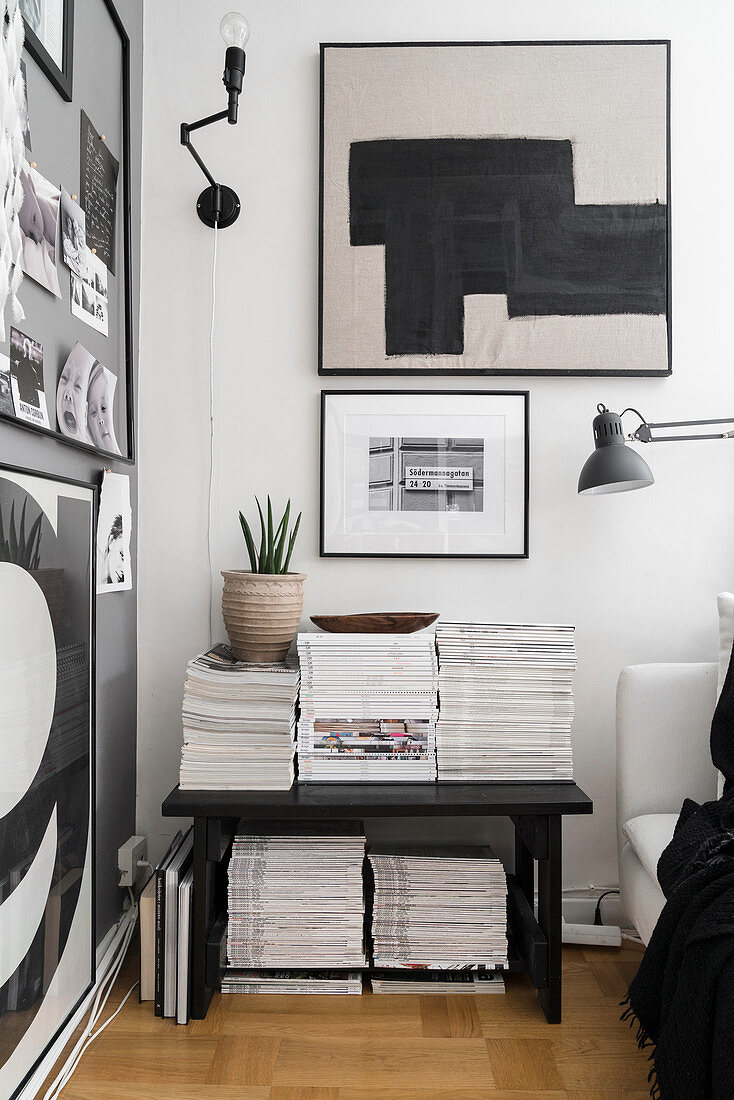 Bank mit Zeitschriftenstapeln im Wohnzimmer in Schwarz-Weiß