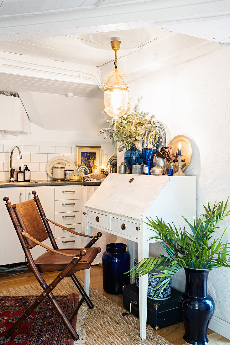 Bureau and leather chair in attic apartment with kitchen counter in background