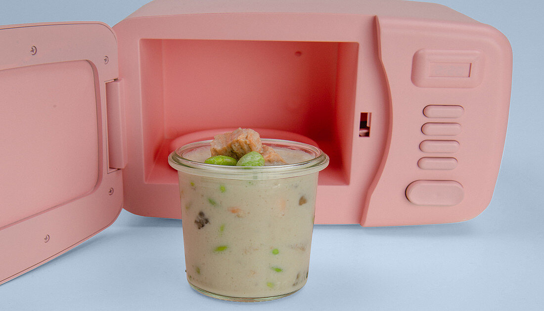 Mushroom soup with leek in front of a mini microwave