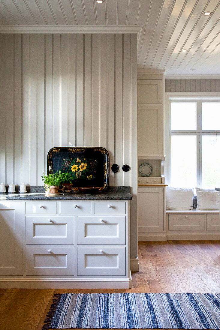 White, spacious country-house kitchen with wood-panelled walls