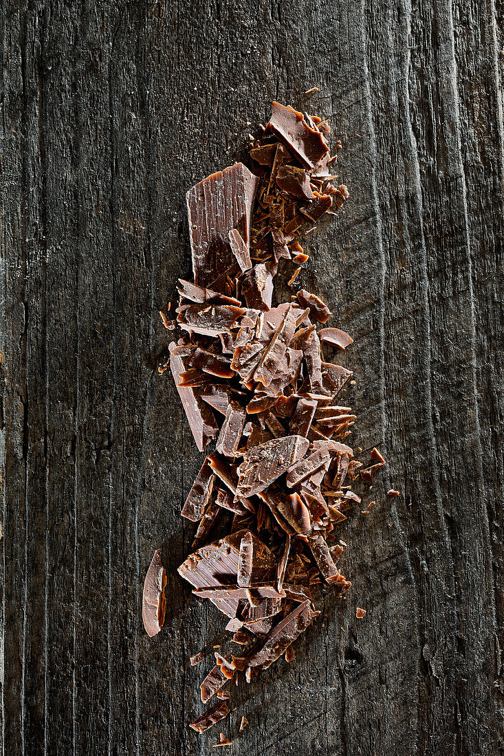 Chopped chocolate on a wooden background