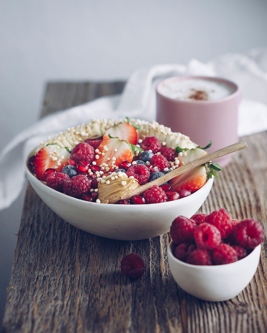 Porridge-Bowl mit Früchten, Kaffee und Himbeeren