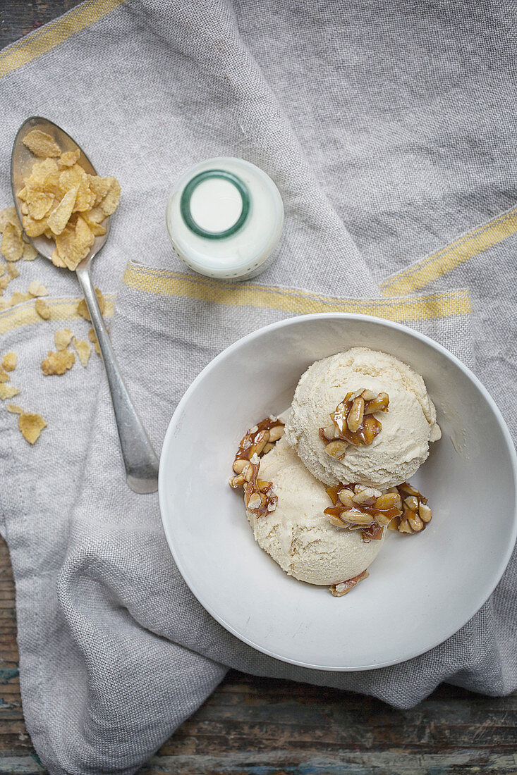 A breakfast bowl with ice cream, nut brittle and cornflakes