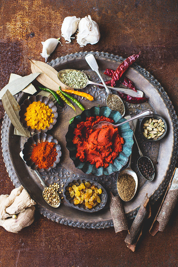 Various spices and sultanas on a metal plate
